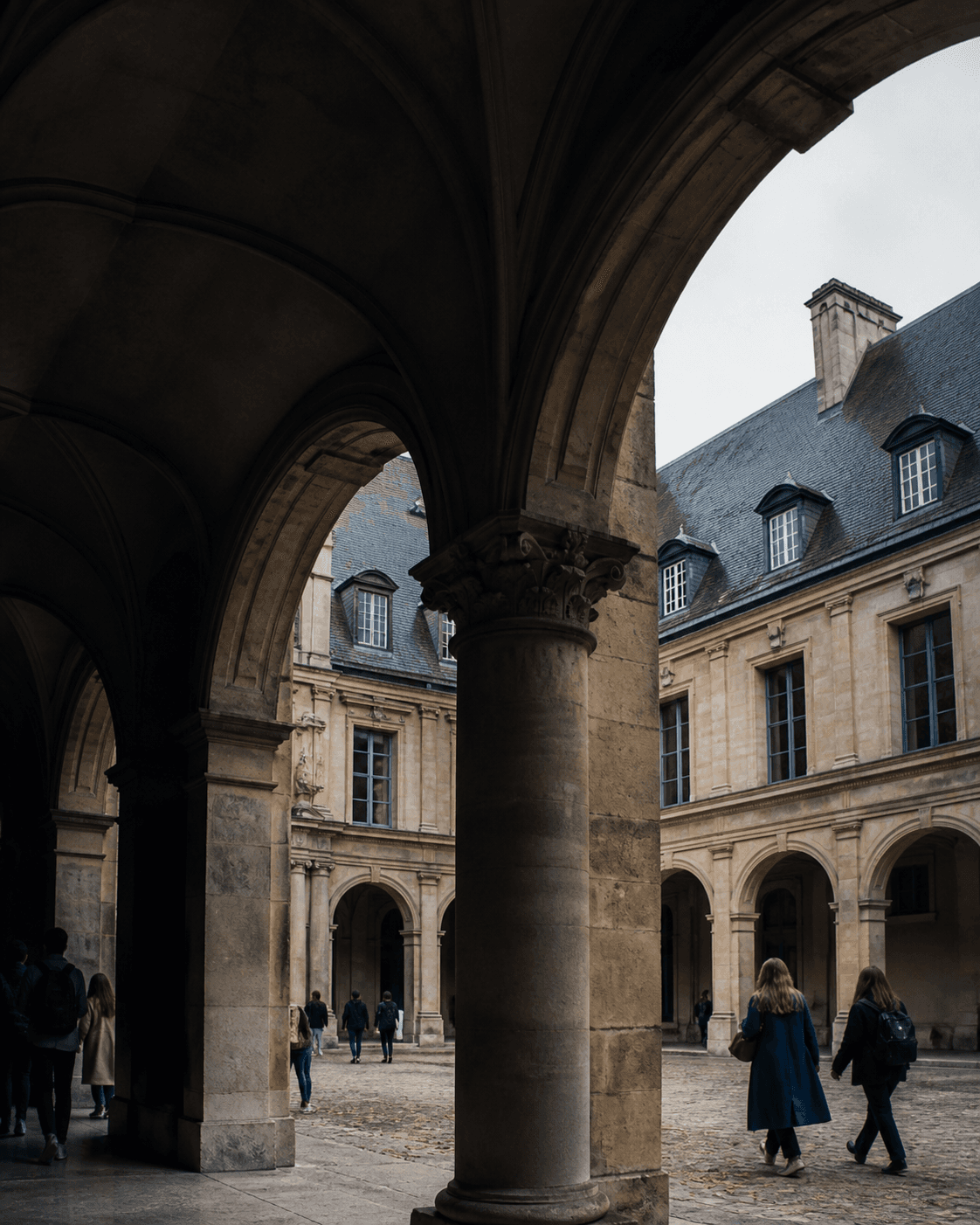 Students crossing a historic European university courtyard